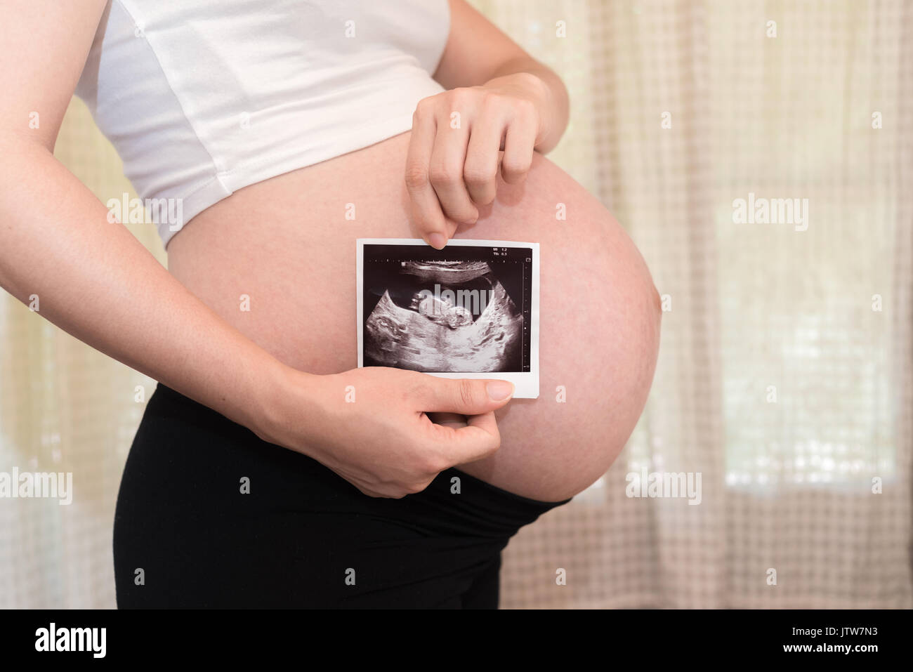 Pregnant woman show ultrasound baby photos, baby coming soon on the world Stock Photo