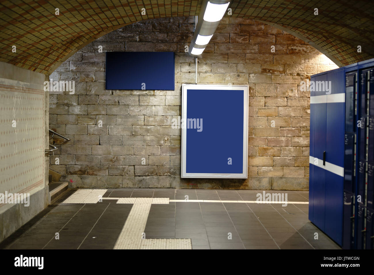 A Lighted And Tiled Station Tunnel With Ceiling Lights And Frames