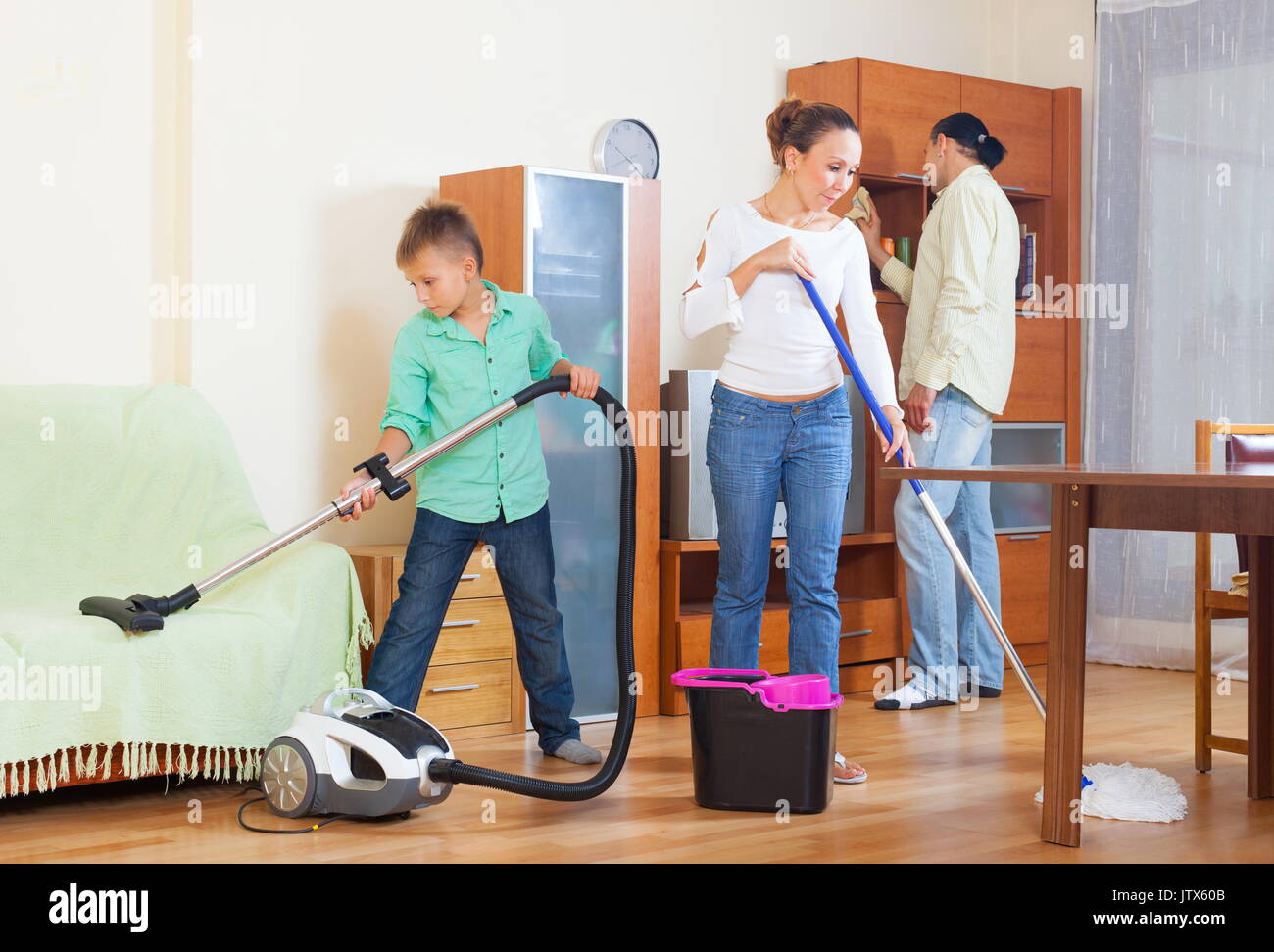 Happy family of three doing housework together Stock Photo