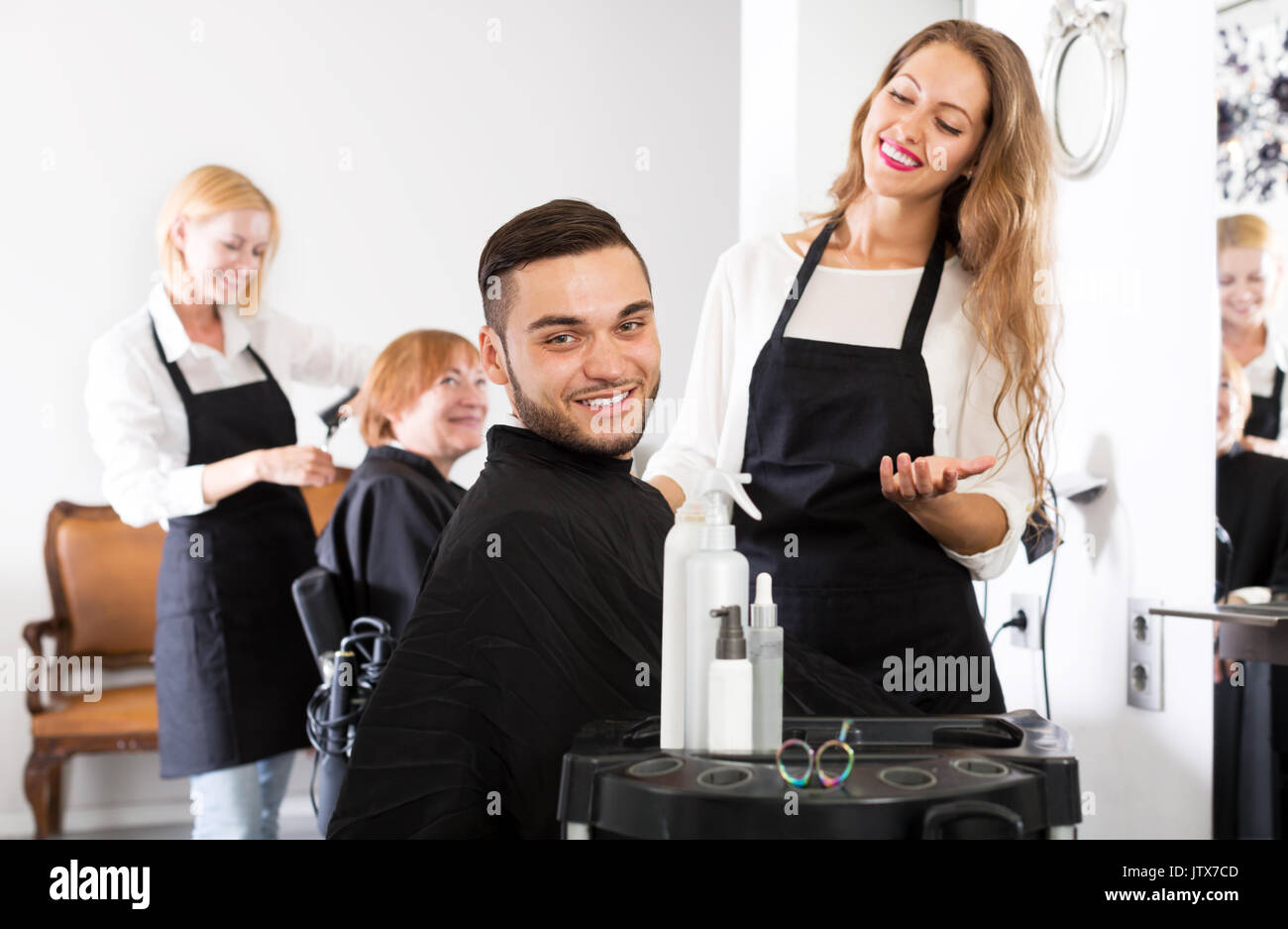 Happy Young Guy Cuts Hair And Female Barber At The Hair Salon