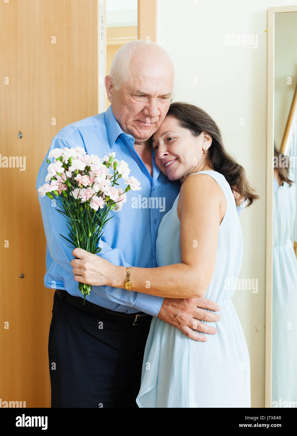 Mature couple greeting  in the doorway  at home Stock Photo