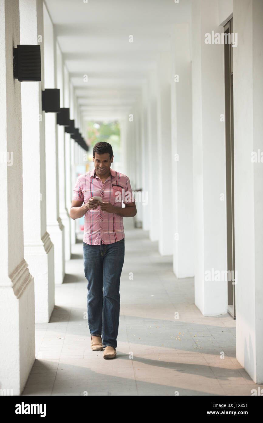 Happy Indian man using a smart phone on street Stock Photo - Alamy