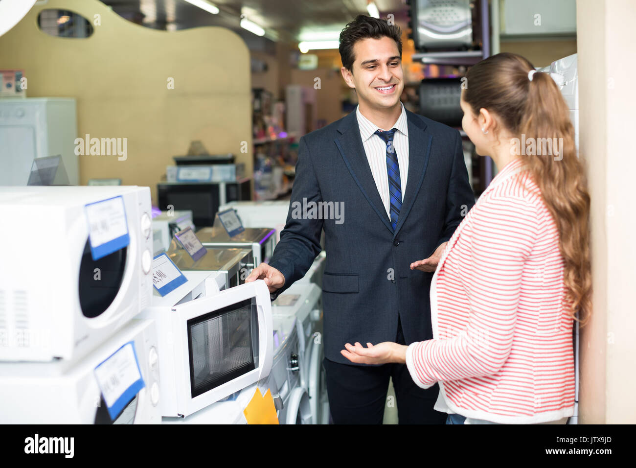 Family couple buying microwave oven in hypermarket and smiling Stock Photo