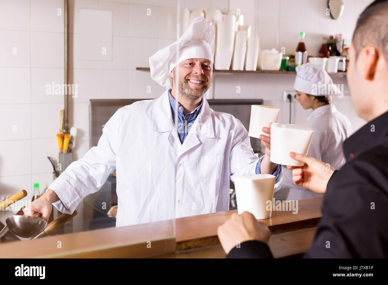 Client Cooking Smiling cook and client buying take-away food at eating house Stock ...
