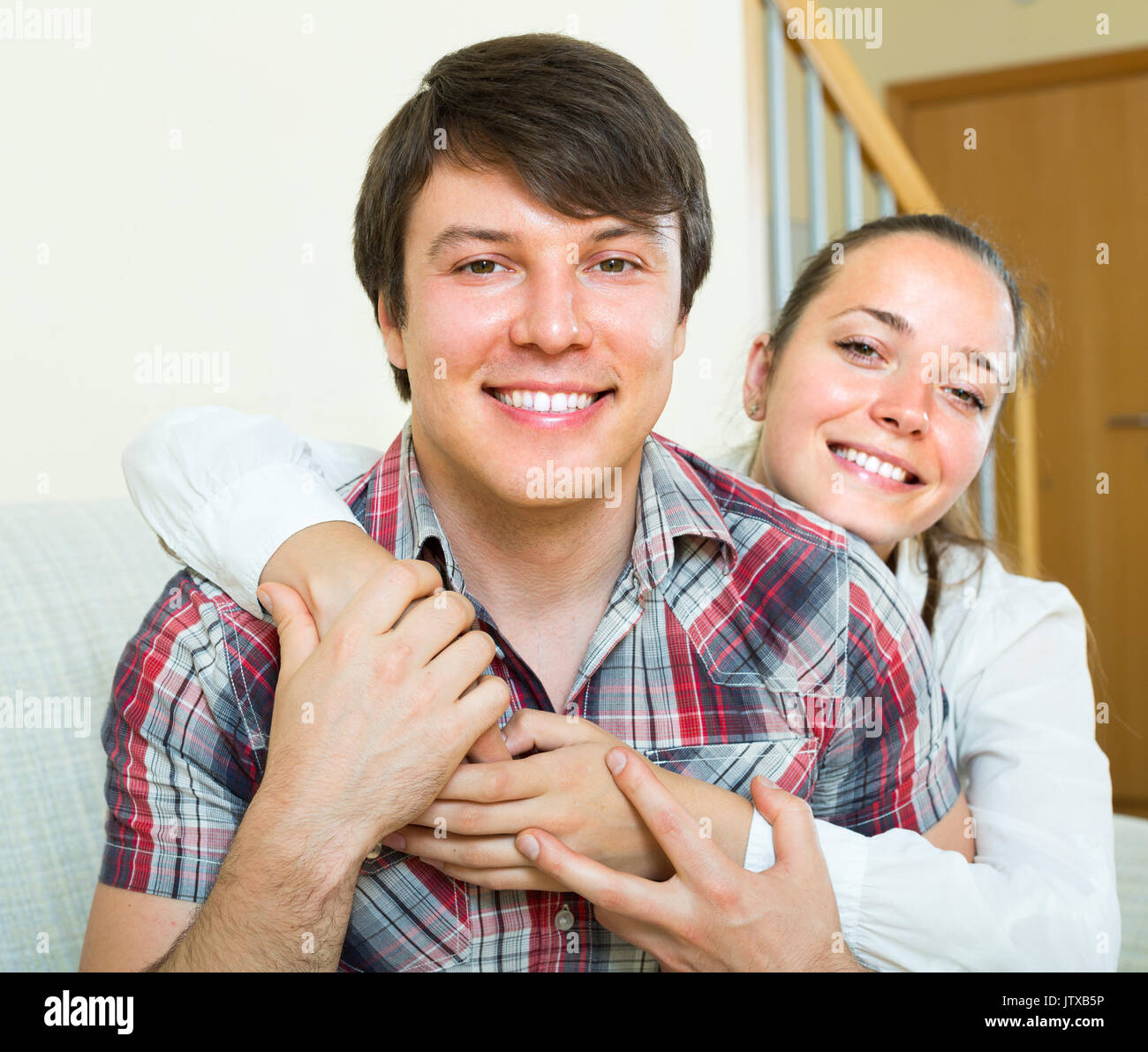 Portrait of happy young smiling couple hugging at home Stock Photo - Alamy