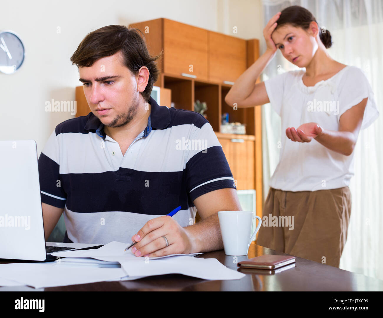 spouse cannot receive attention from partner freelancer in apartment Stock Photo