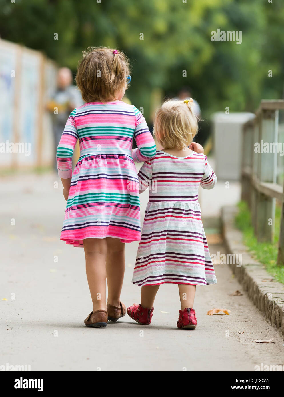 Rear view of two children at street Stock Photo - Alamy