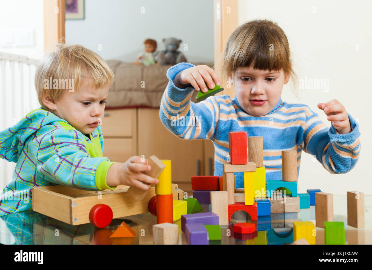 Two children playing with wooden blocks in home Stock Photo - Alamy