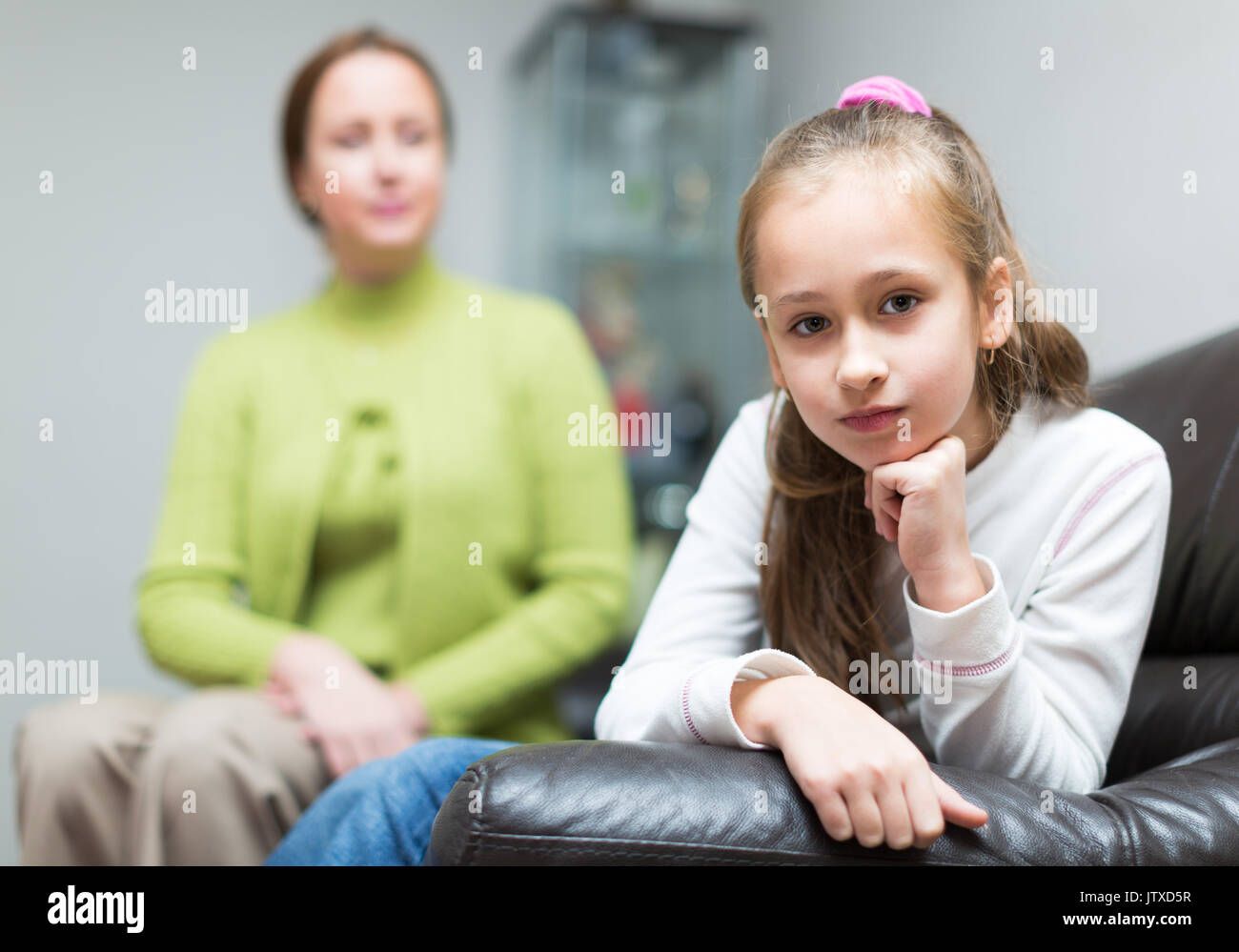 Mother berating  7-8 years old daughter at interior Stock Photo