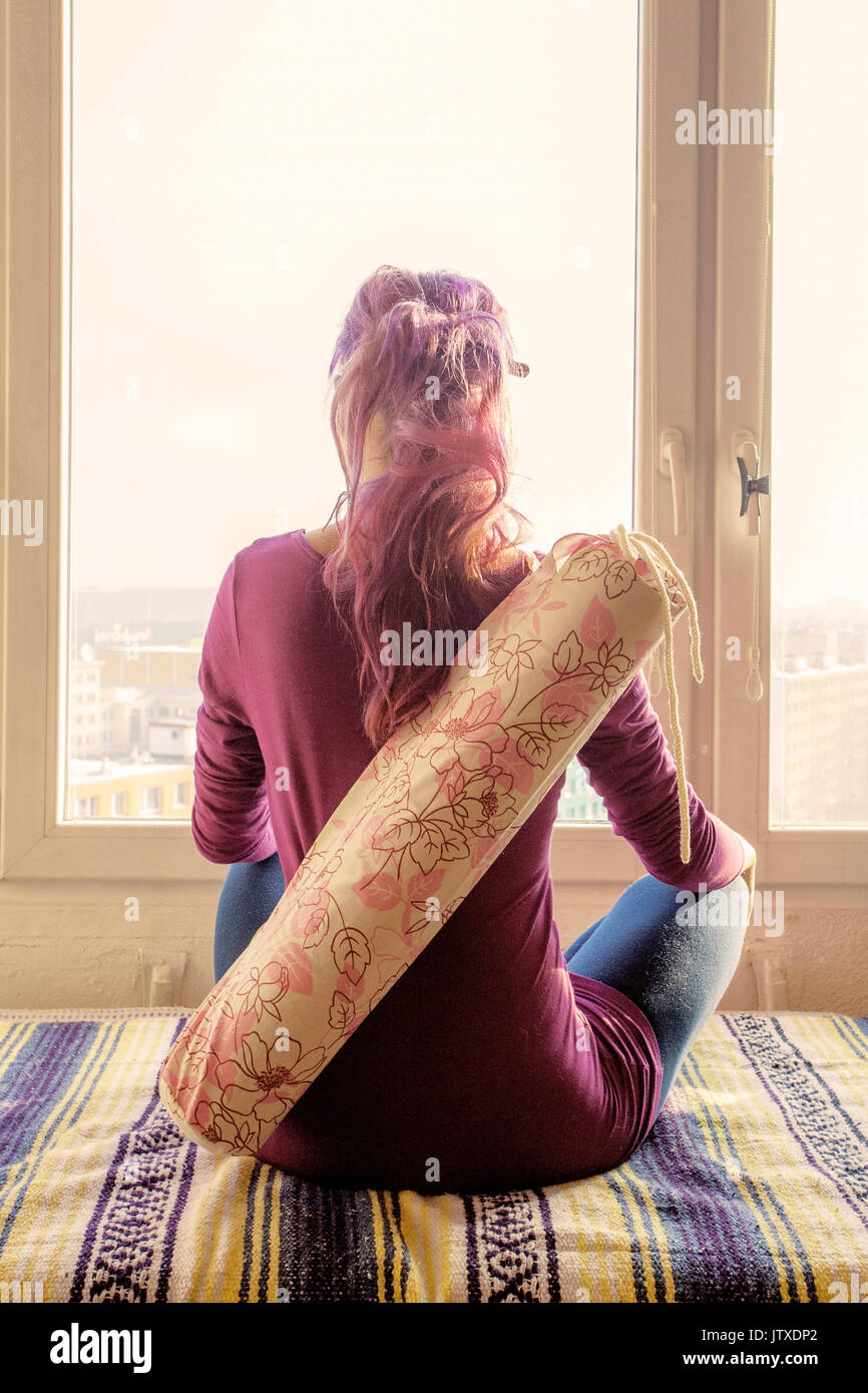 Girl sitting with her yoga mat Stock Photo