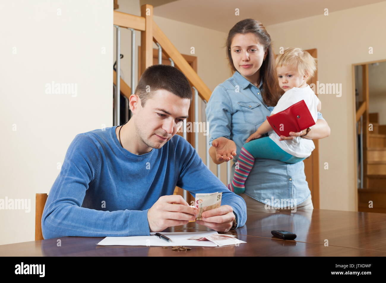 Quarrel in the family of three due to lack of money Stock Photo
