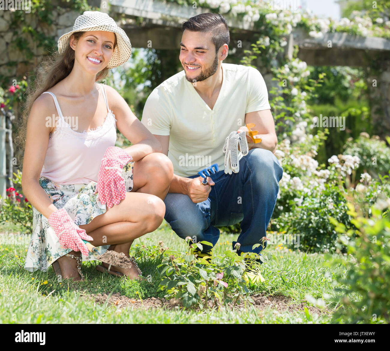 Happy smiling couple gardening together at summer day Stock Photo - Alamy