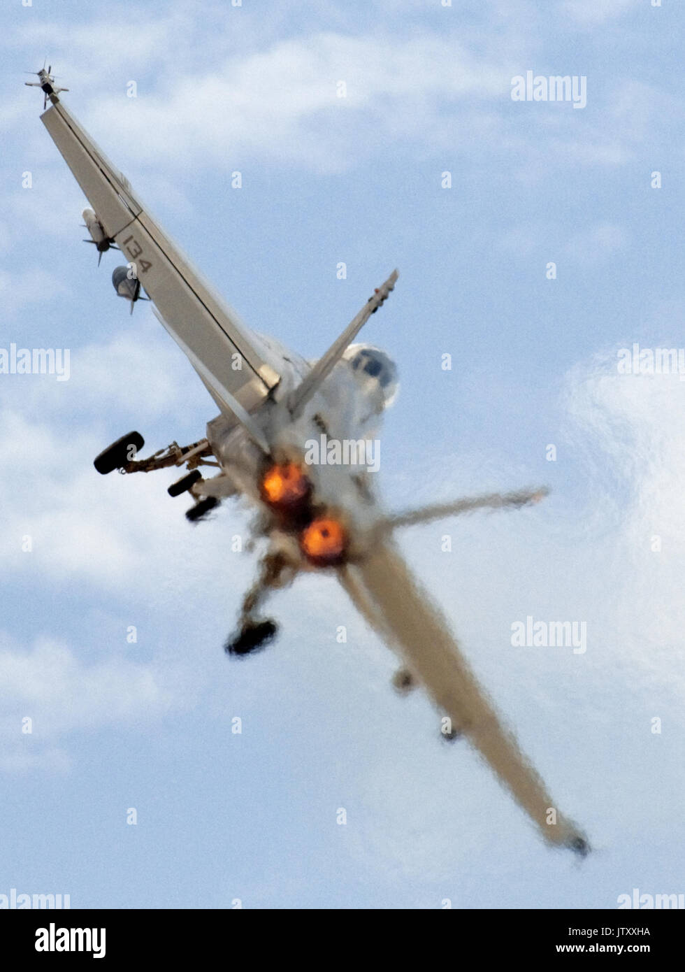 Rear end portrait view of an F/A18 Super Hornet with full afterburners on, at takeoff. Stock Photo