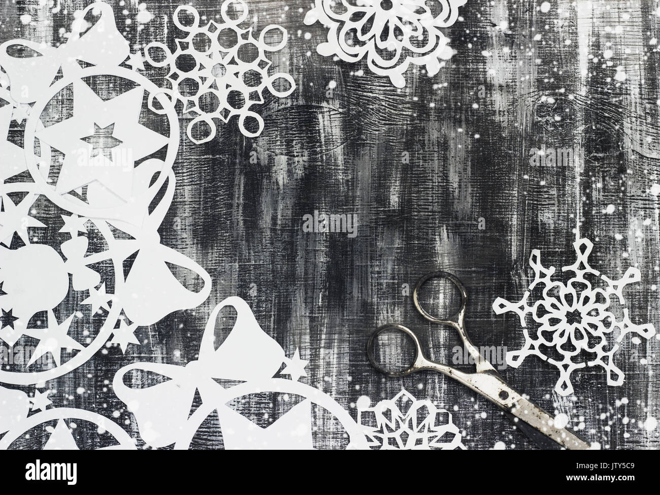 Snowflakes cut out of paper on dark old background with space for text ...