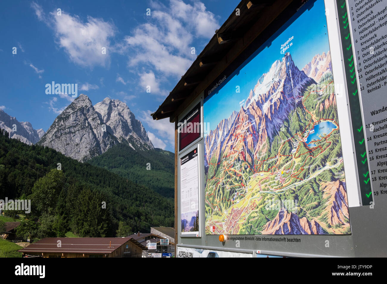 Information sign at the Kreuzakbahn cable car base with the Alpspitz peak behind, Zugspitzland, Bavaria, Germany Stock Photo
