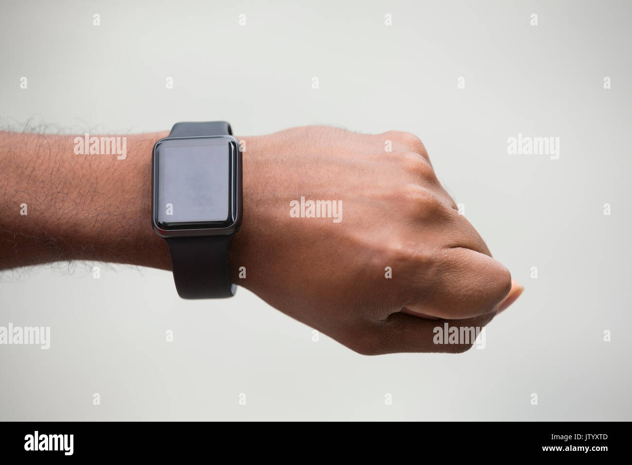 Close up of an Indian man looking at his smartwatch heart rate monitor. Asian man using a smart watch. Stock Photo