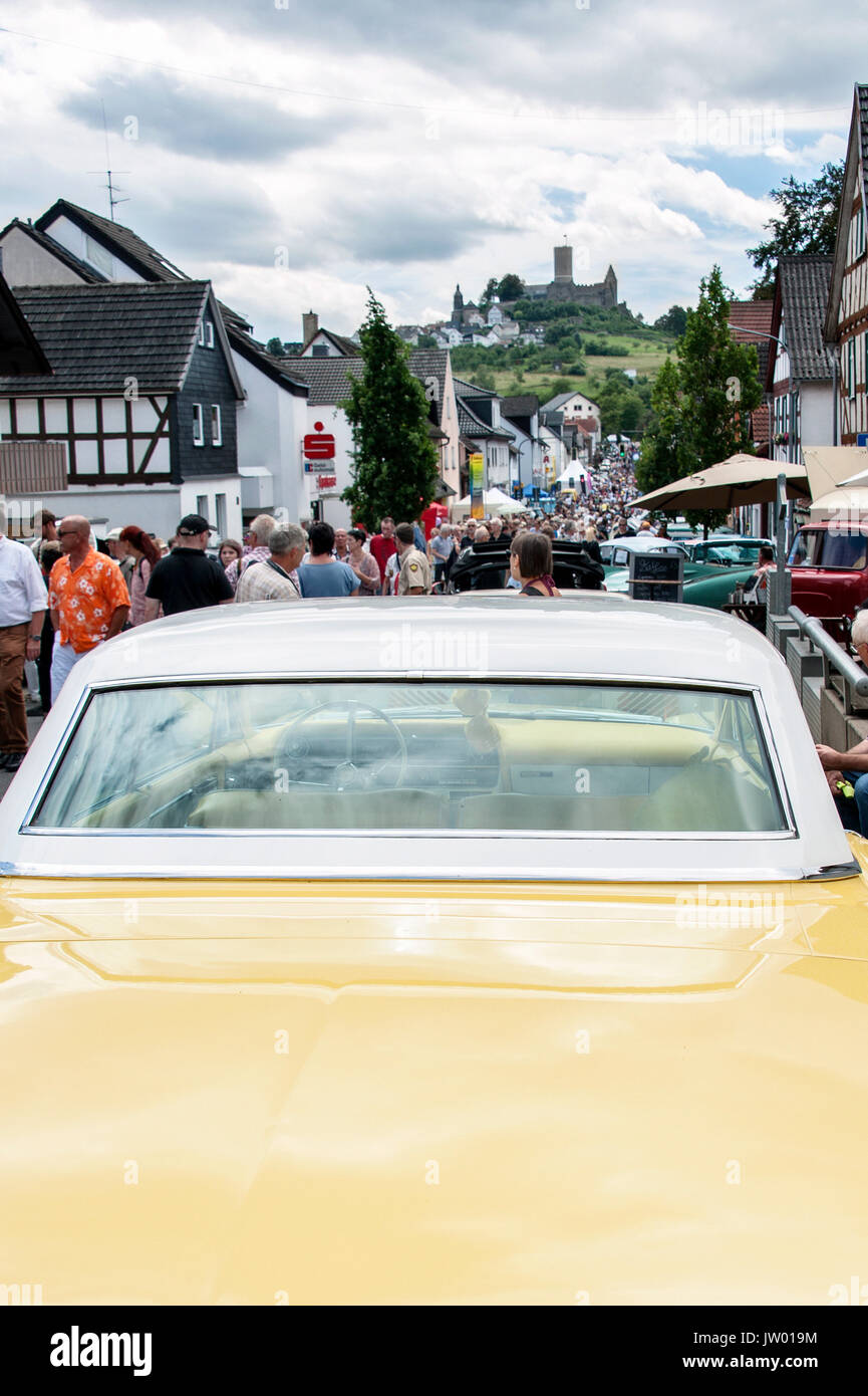 Vintage Car Festival 'Golden Oldies', yellow vintage car and visitors on the main street below the castle. Stock Photo