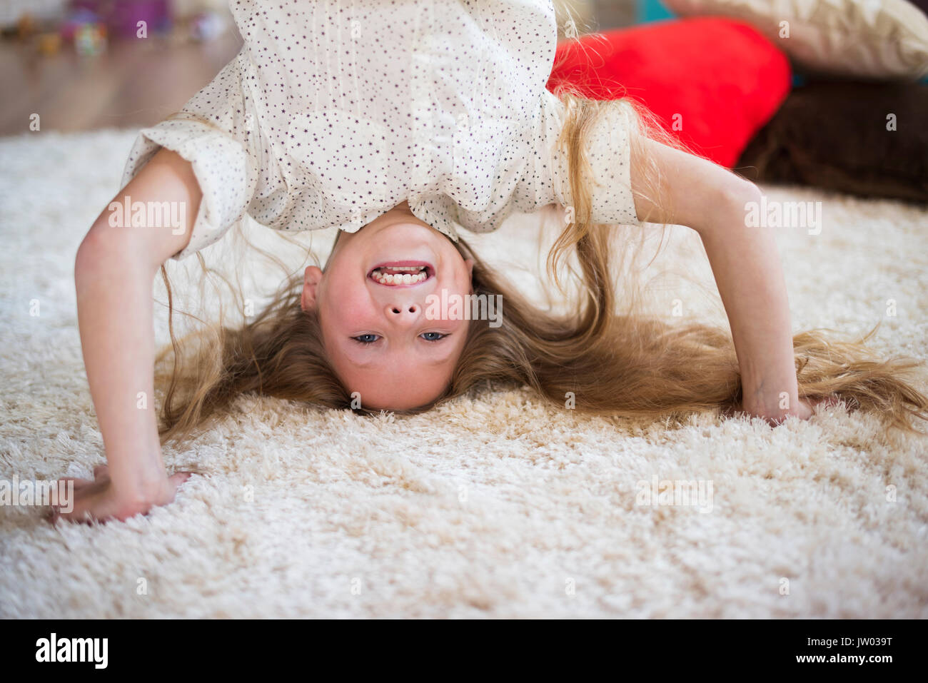 Joyful girl showing a headstand pose Stock Photo