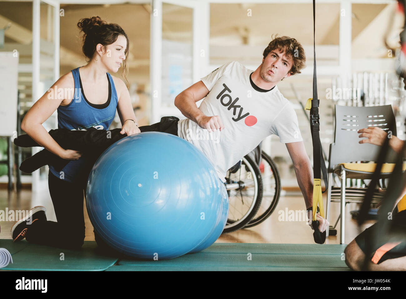 Mid adult man practicing with dumbbells during physiotherapy session Stock Photo