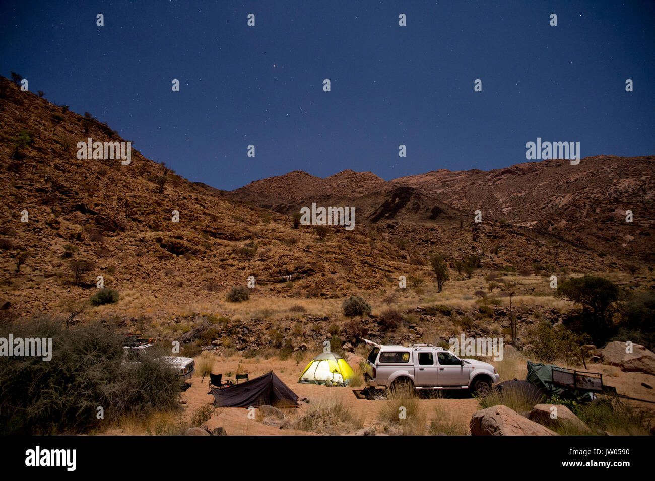 Tourist camp with tents and 4x4 car at night, Brandberg mountain, Damaraland, Namibia Stock Photo