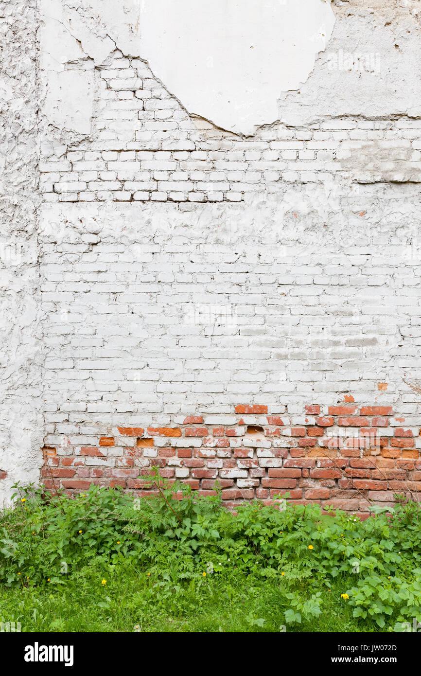 Aged brick wall with cracked plaster Stock Photo