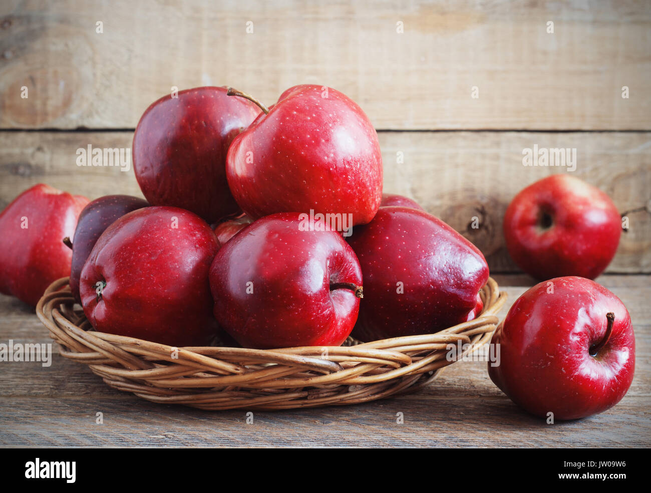 A beautiful red apples in a wicker basket on a wooden background Stock ...