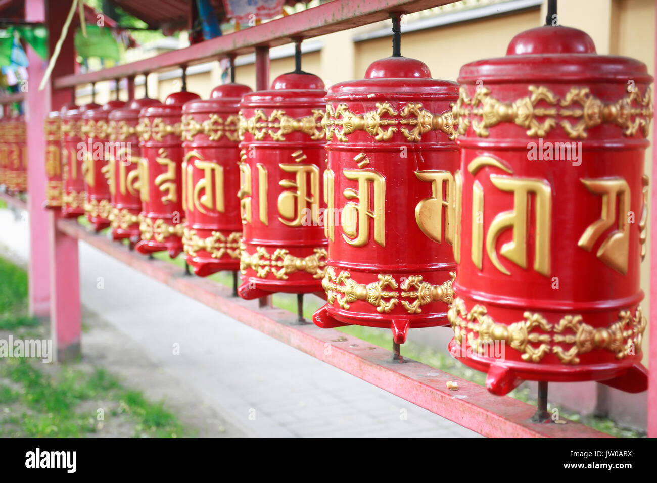 Detail of a Lamaism Datsan temple with red drums in a row Stock Photo