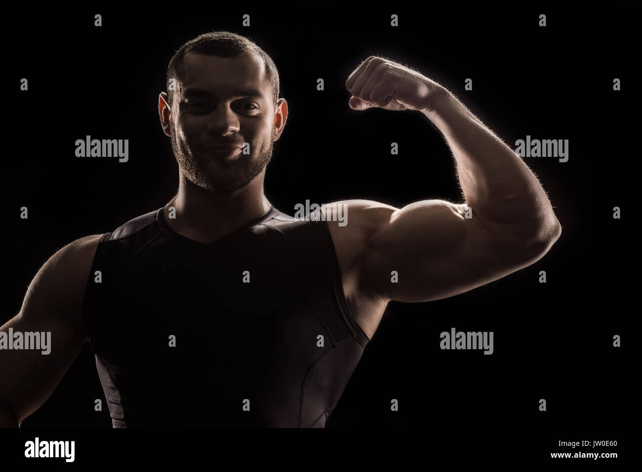 young caucasian bodybuilder flexing biceps and looking at camera Stock Photo