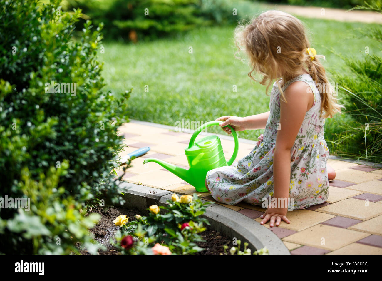 Cute little girl watering plants in the garden. Stock Photo