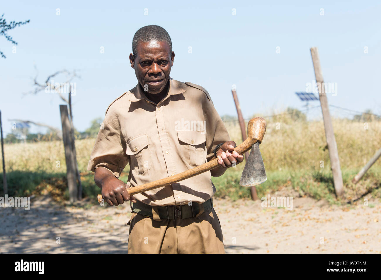 Elderly local Zimbabwean man with a hand-made traditional axe made from forged steel and a Mopane wood handle Stock Photo