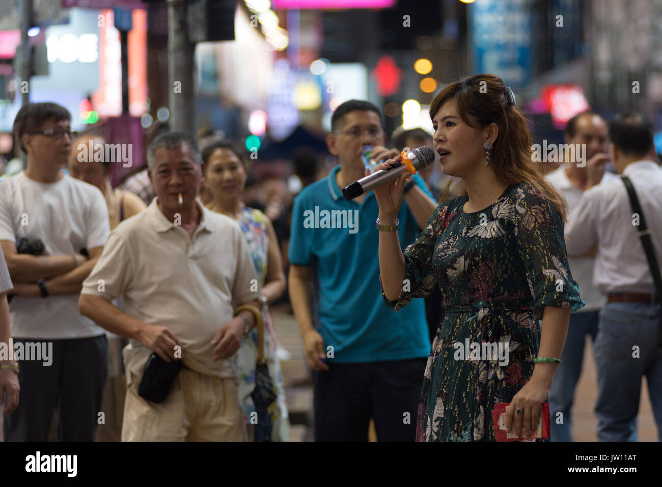 A street singer performs in a walking street of Mongkok, Hong Kong. Stock Photo
