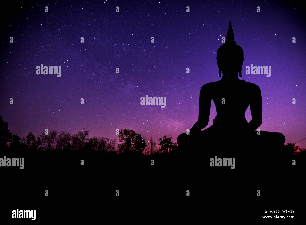 The Milky Way and silhouette of buddha statue. Stock Photo