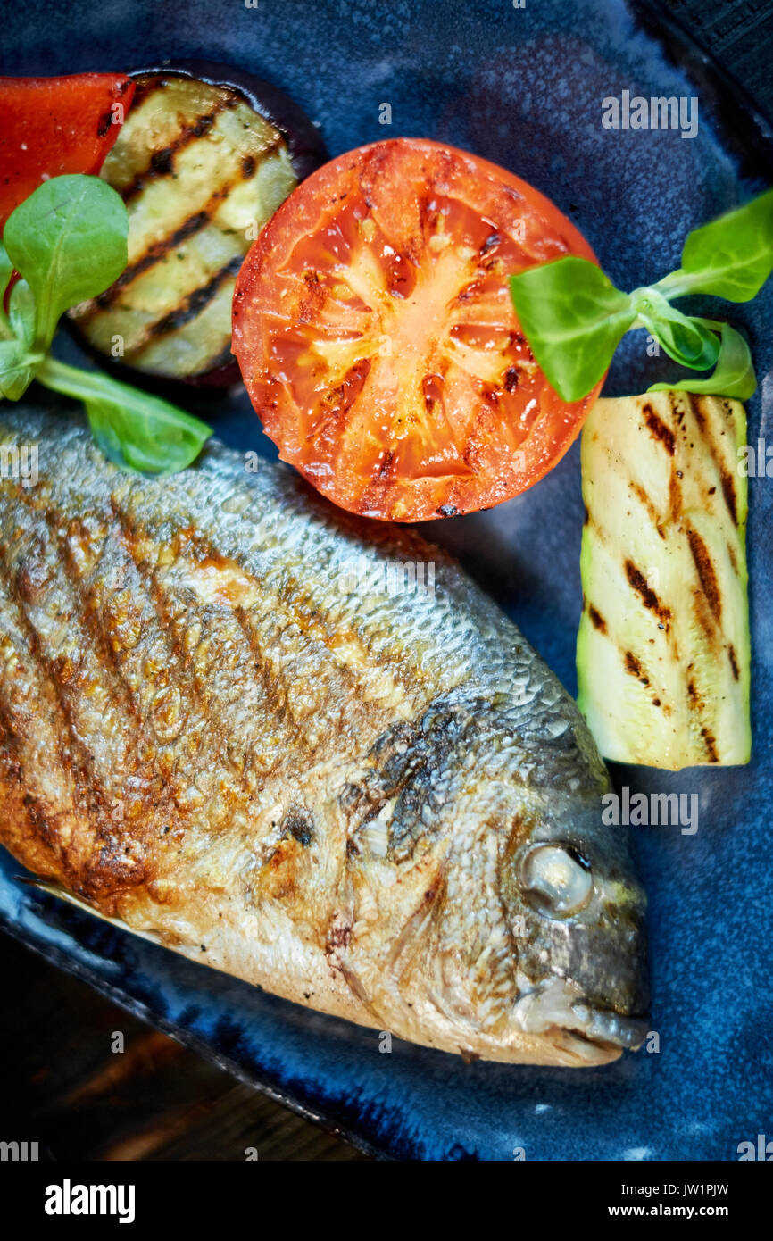 Grilled Fish dish - roasted fish and vegetables jpg Stock Photo - Alamy