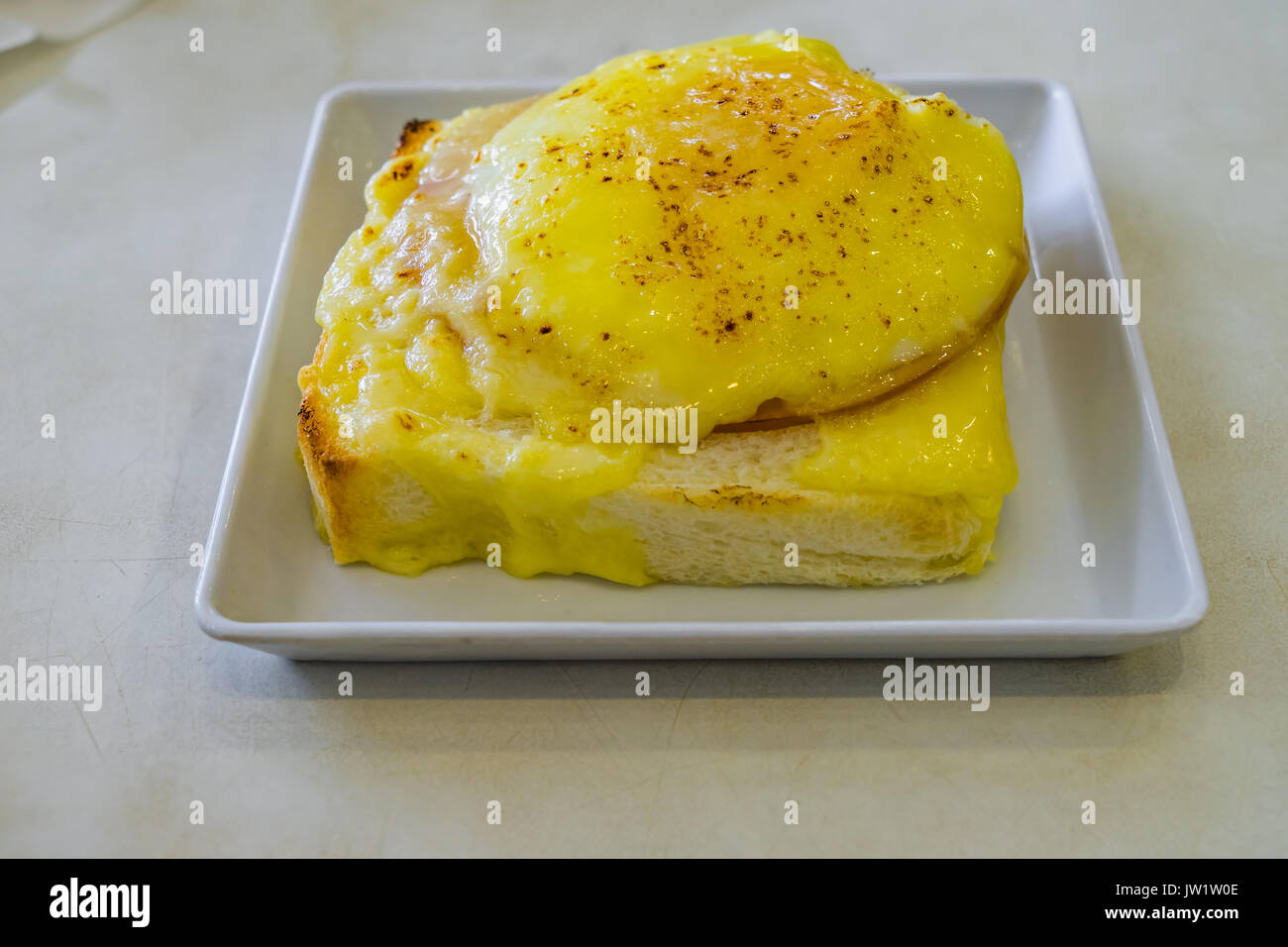 Ham and Cheese Stuffed French Toast on White table and sunny side up