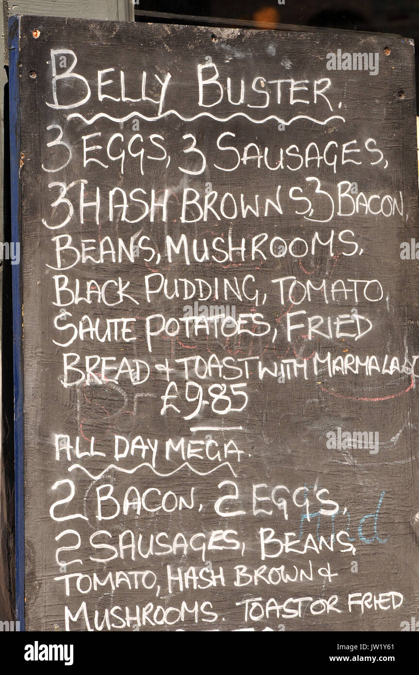 a hand written blackboard outside of a greasy spoon café or truckers café advertising a belly buster breakfast. Unhealthy, greasy, fattening foods. Stock Photo