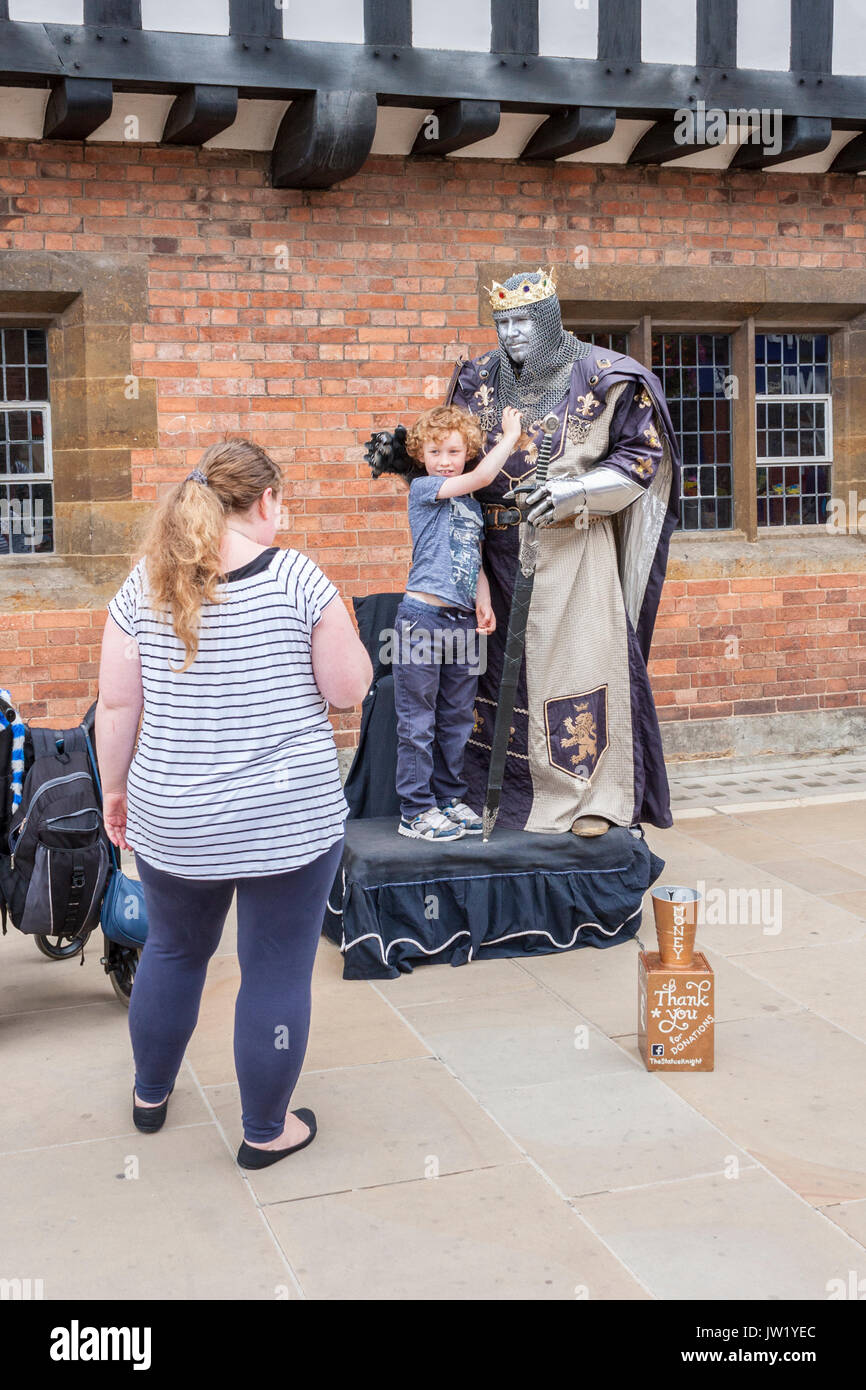 A boy has his photo taken with a living statue mime artist in Stratford-upon-Avon Stock Photo