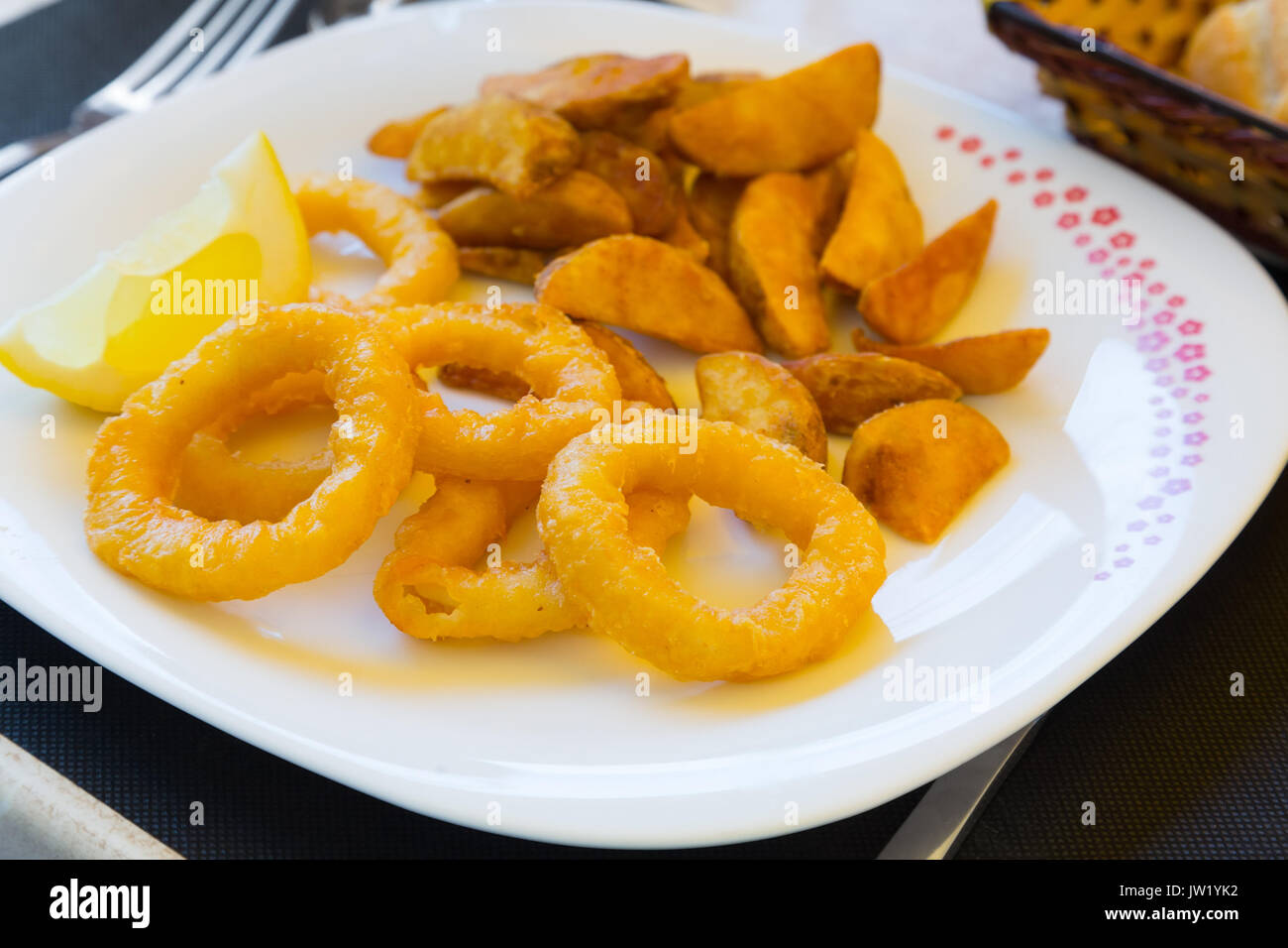 Calamares a La Romana Fried Squid   on  plate at  table Stock Photo
