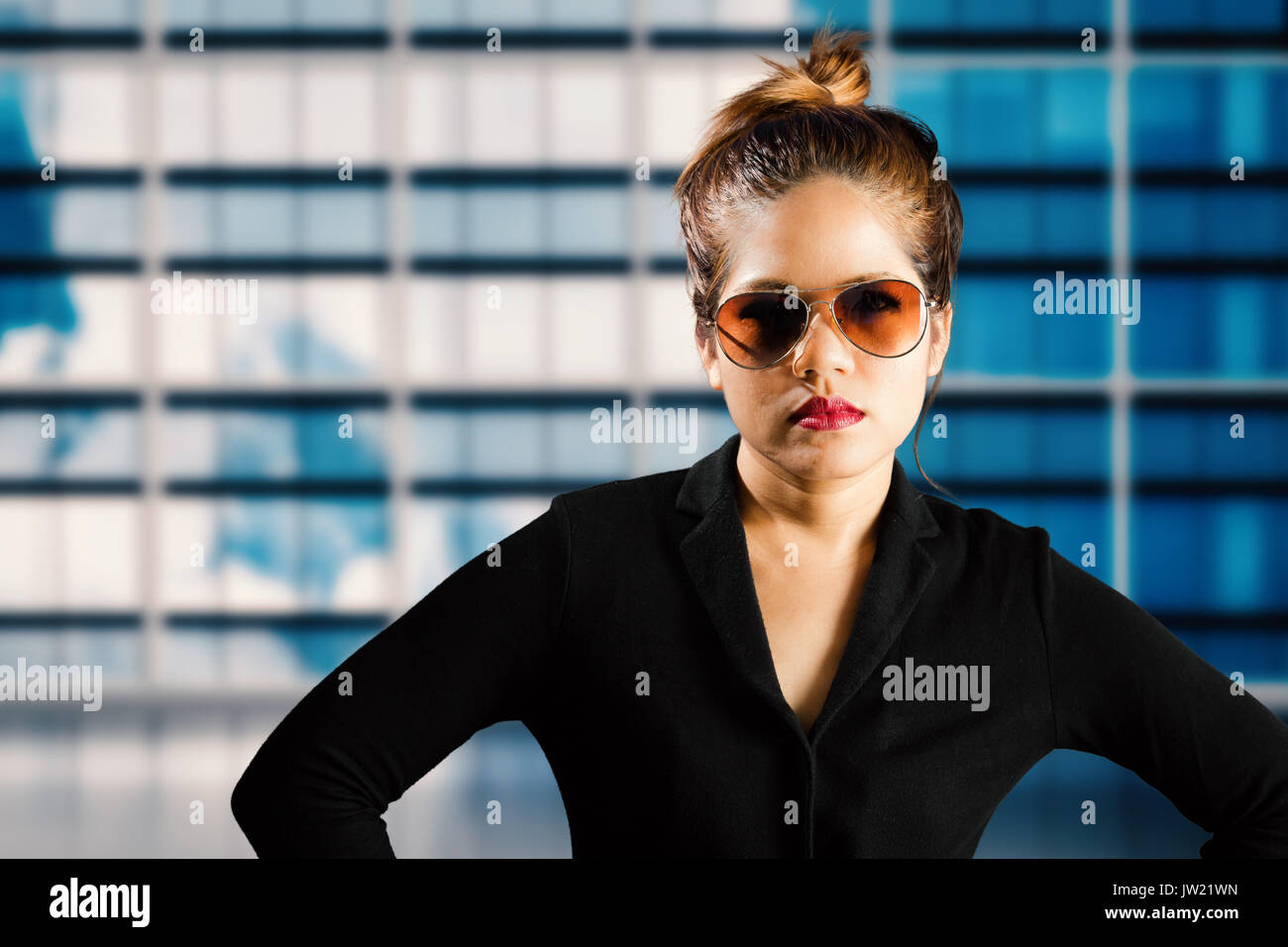 businesswoman wearing sunglasses and red lips with building background Stock Photo
