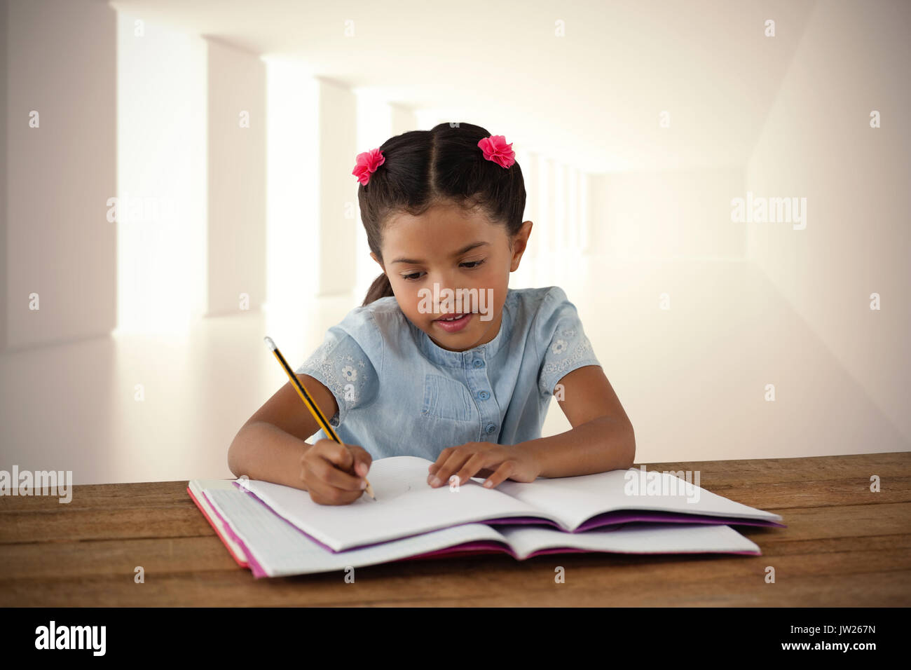 Girl writing in book at desk against digitally generated room Stock Photo