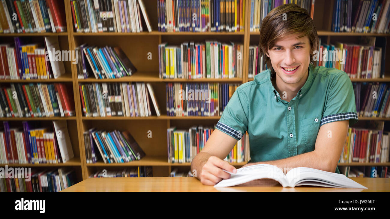 Student sitting in library reading  against various books on shelf Stock Photo