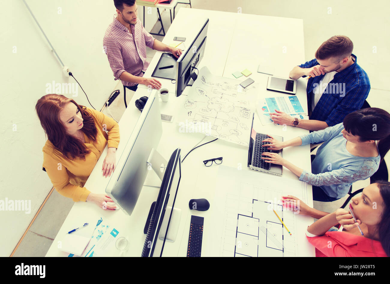 creative team with computers, blueprint at office Stock Photo - Alamy