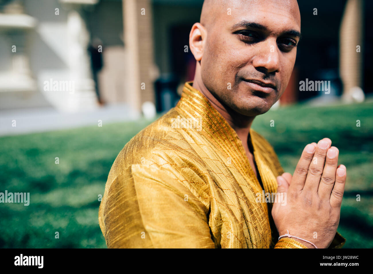 Handsom Indian Man Greeting Namaste, in Gold Kurta at the Temple Stock Photo