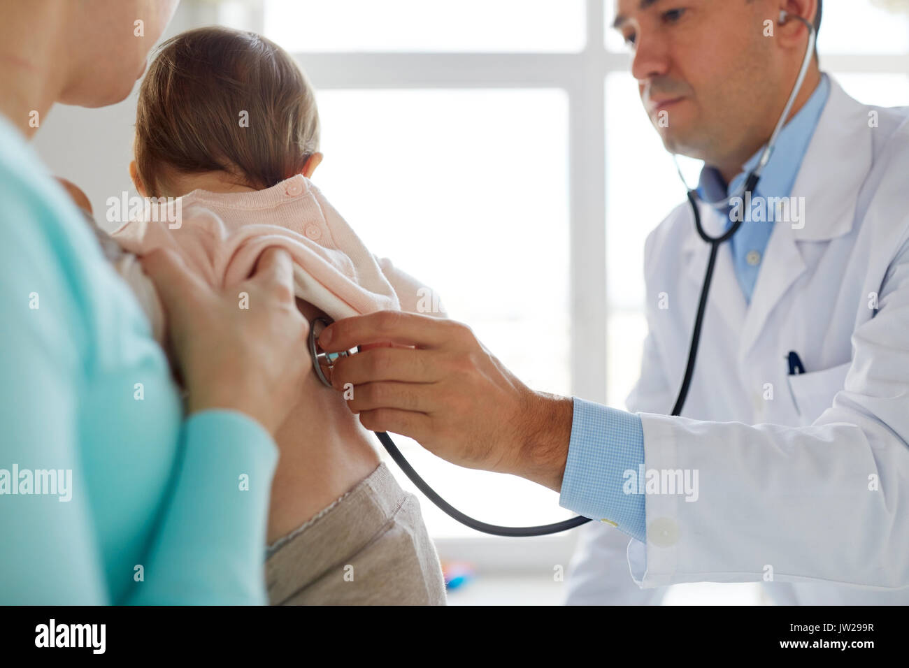 doctor with stethoscope listening baby at clinic Stock Photo - Alamy