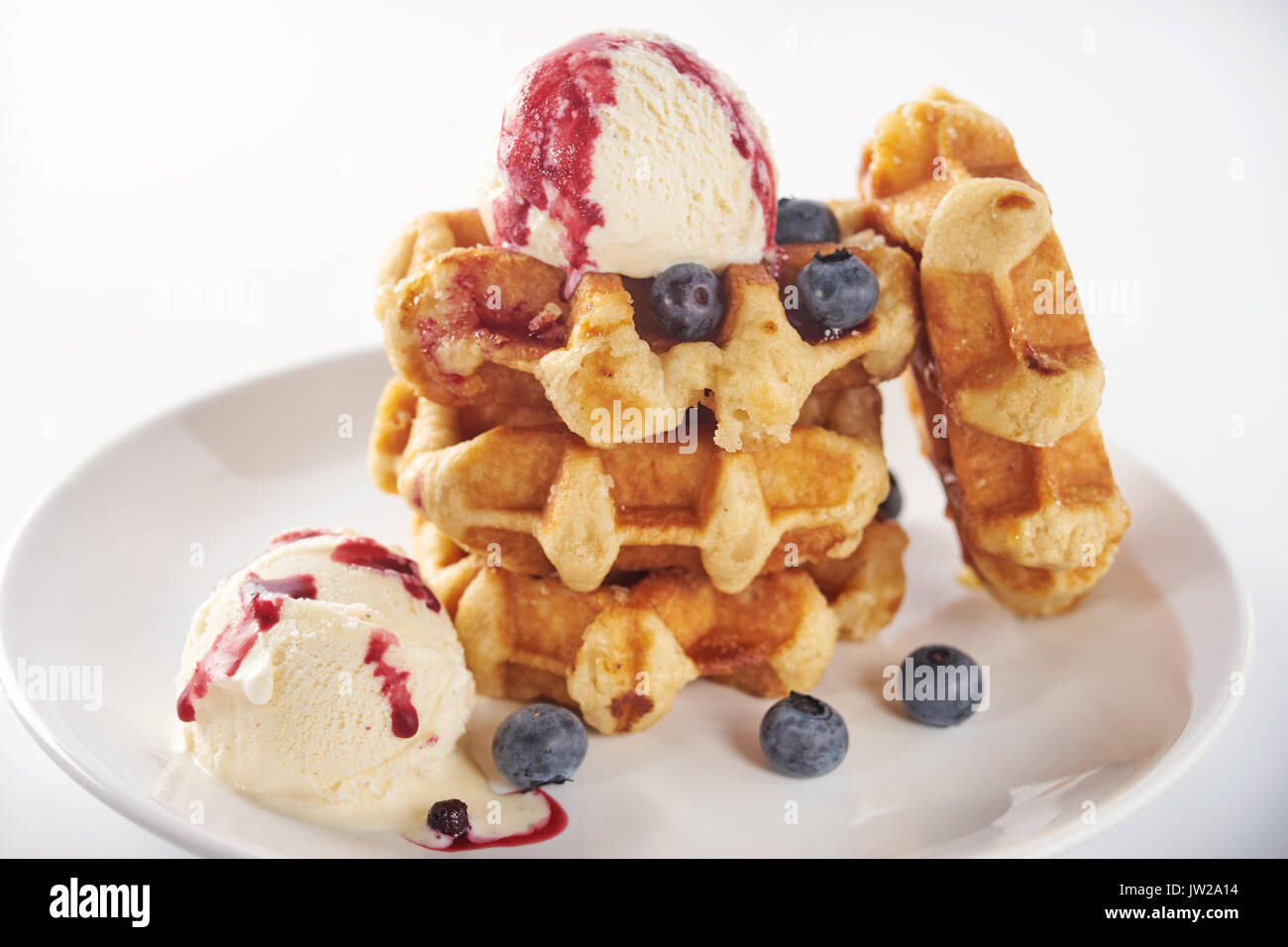Pile of belgian waffles with ice cream ball on top and berries isolated ...