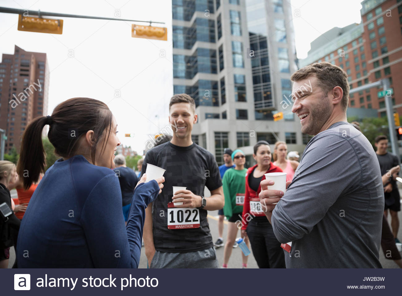 Marathon runners talking and drinking water on urban street Stock Photo Alamy