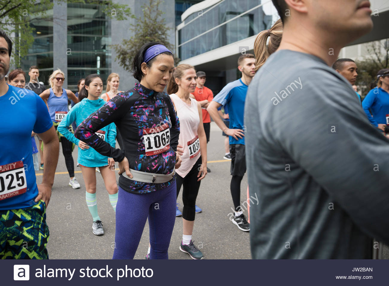 Tired female marathon runner resting with hands on hips Stock Photo