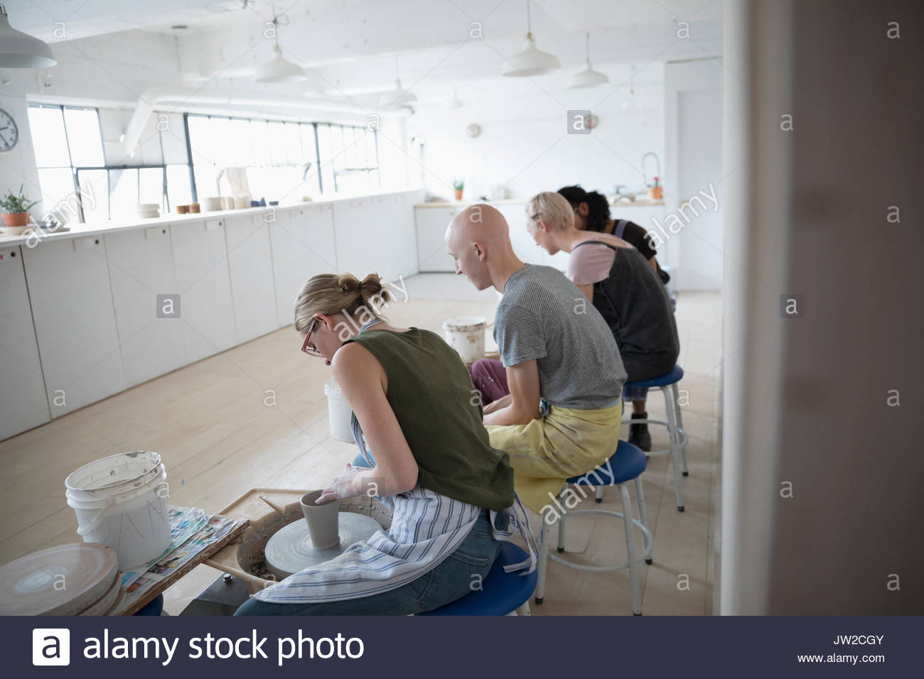 Pottery students using pottery wheels in art studio Stock Photo Alamy