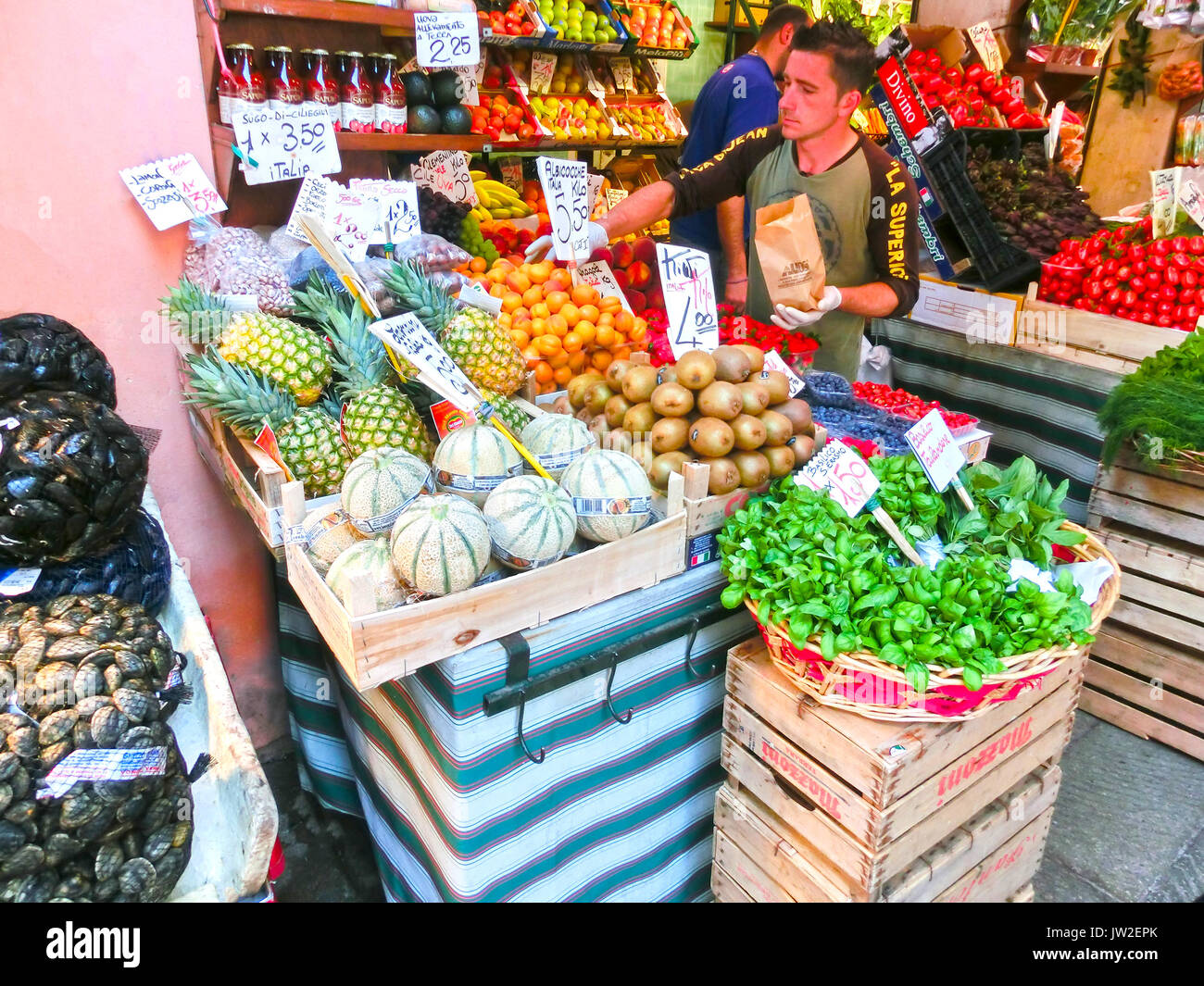 Venice, Italy - May 10, 2014: People near a counter with vegetables on market Stock Photo