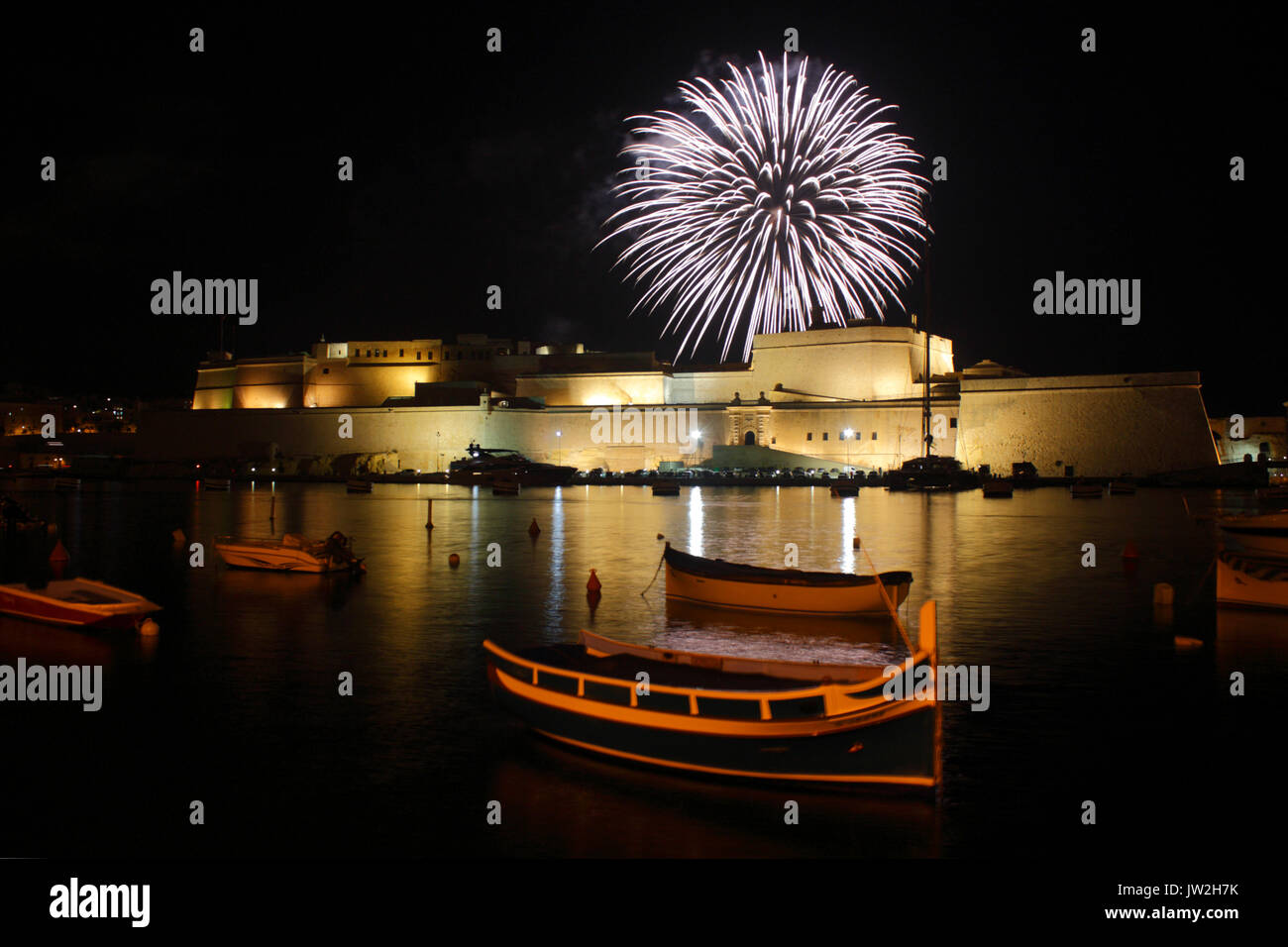 A firework explodes behind Fort St Angelo, Malta, during annual feast day celebrations in the town of Birgu (Vittoriosa) Stock Photo