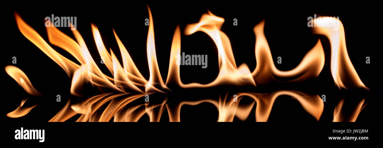 Fire and flames reflecting on a glass mirrored surface, black background Stock Photo